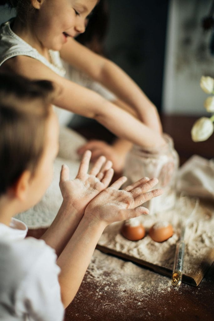 niños cocinando con harina y huevos